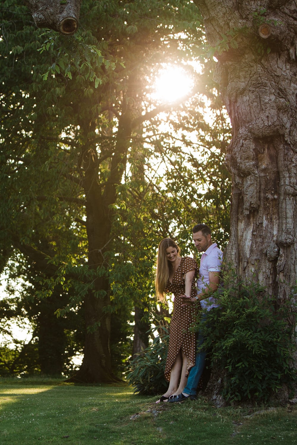 couple admiring engagement ring under tree torworth court wedding photographer