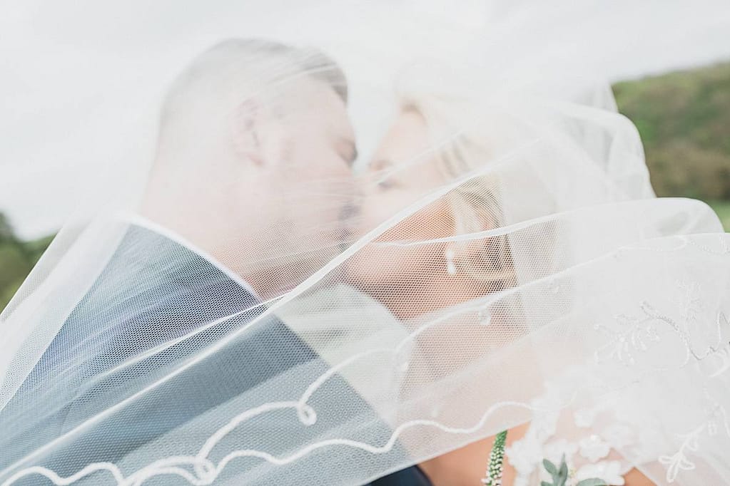 couple kissing under veil Kingscote Barn wedding photographers