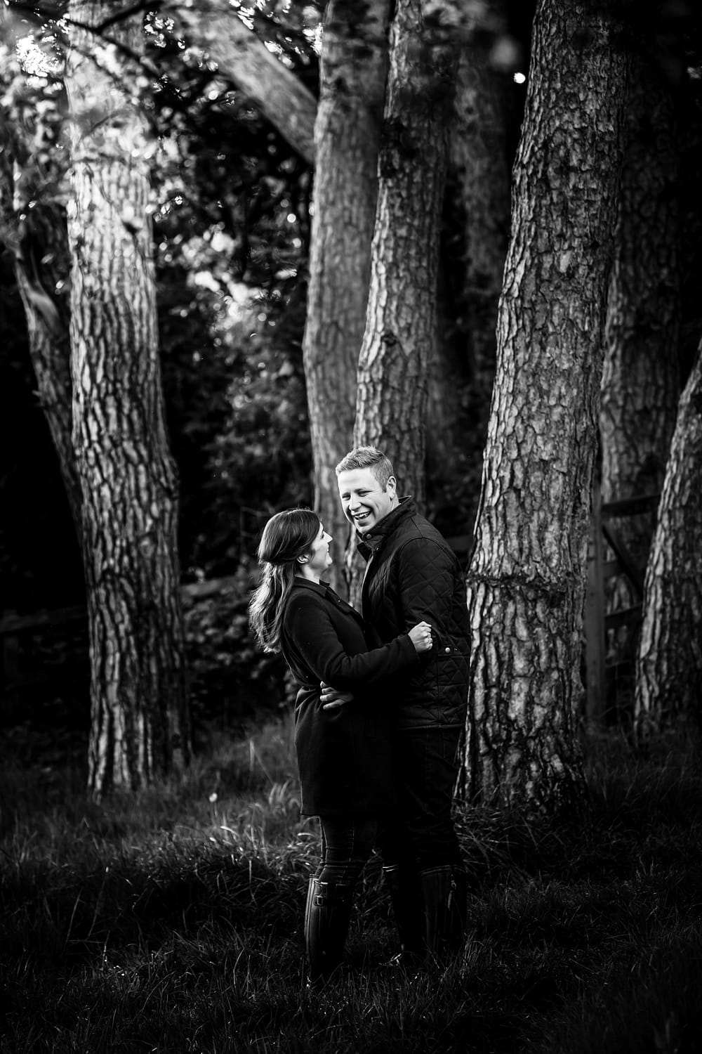 couple laughing under trees for gloucestershire wedding photographer