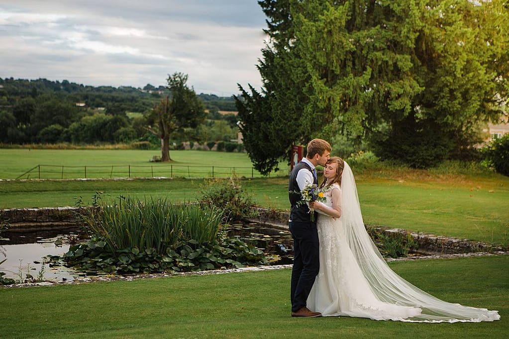 couple kissing in front of gloucestershire wedding venue