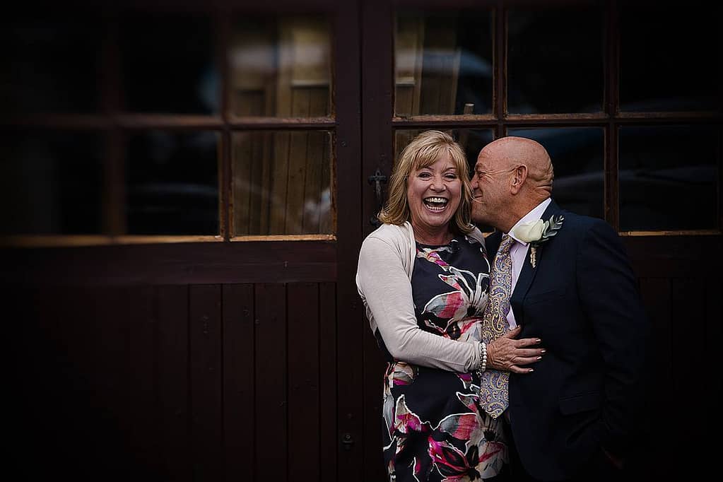 COUPLE CUDDLING AND LAUGHING FOR GLOUCESTERSHIRE WEDDING PHOTOGRAPHER