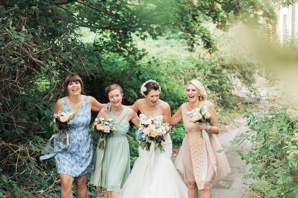 bride and bridesmaids wedding portrait laughing
