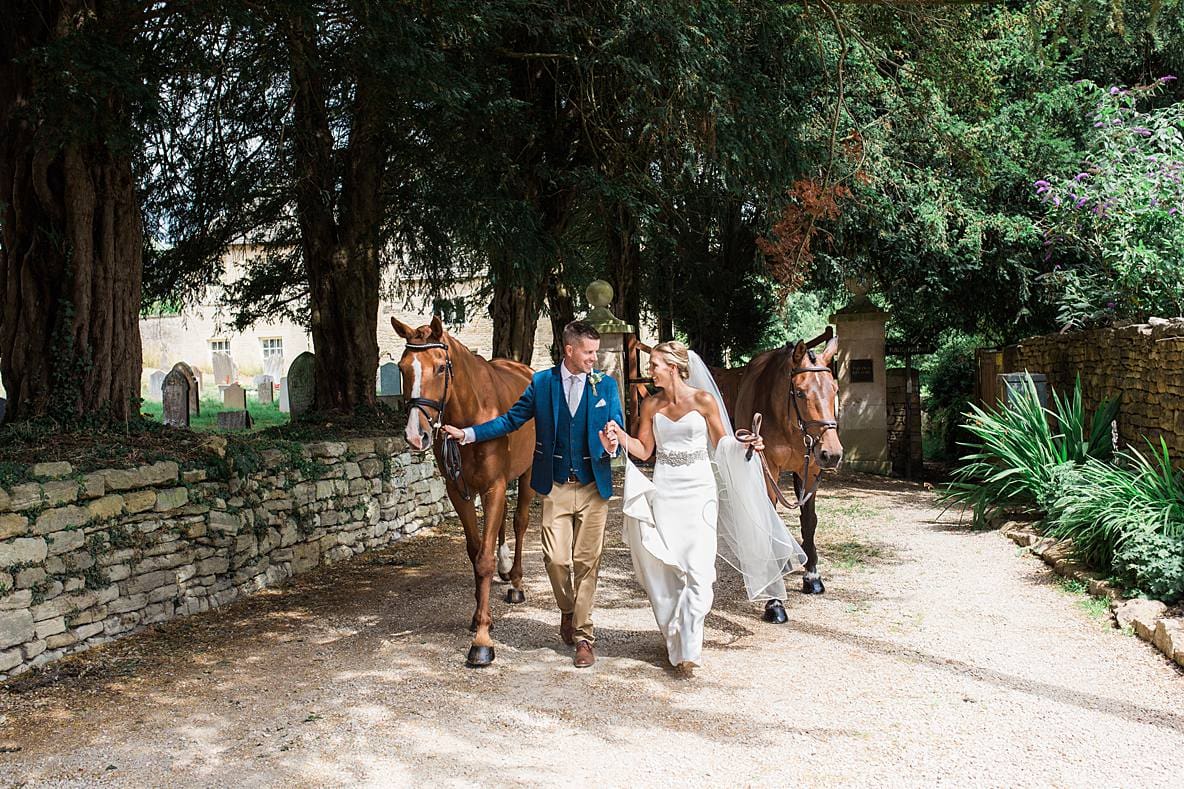 wedding couple walking with horses upcote barn wedding photographer