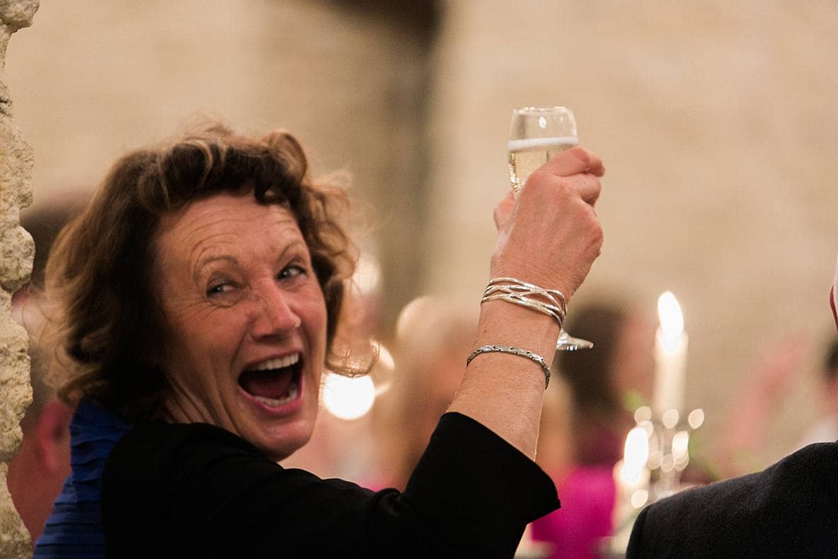 guest laughing saying cheers Kingscote Barn wedding photography