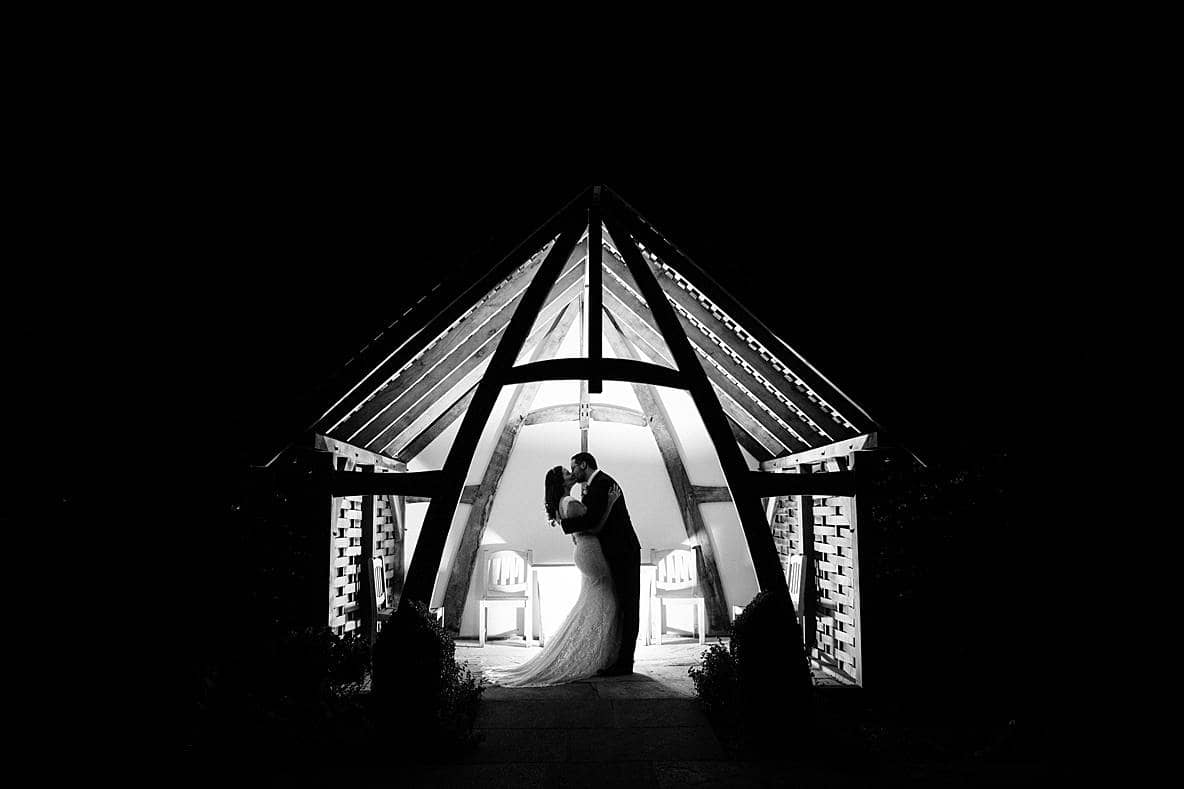 black and white wedding photographer Kingscote Barn couple kissing