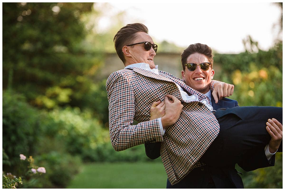men lifting each other up Barnsley House for cotswold wedding photographer