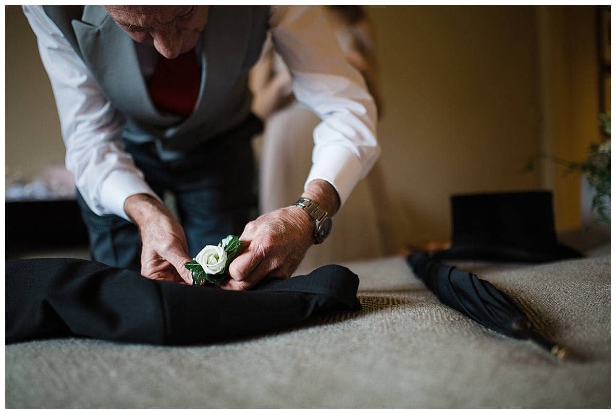 dad of the groom putting on buttonhole bowood hotel golf and spa wedding