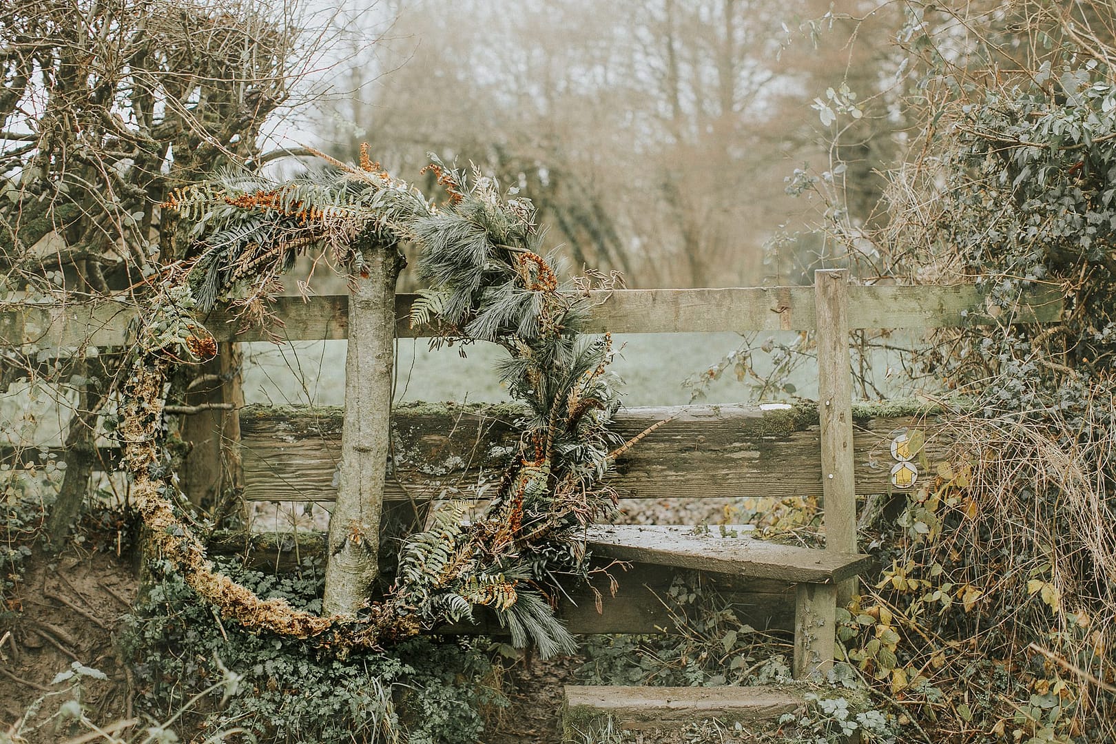 large wreath leaning on fence rustic wedding ideas