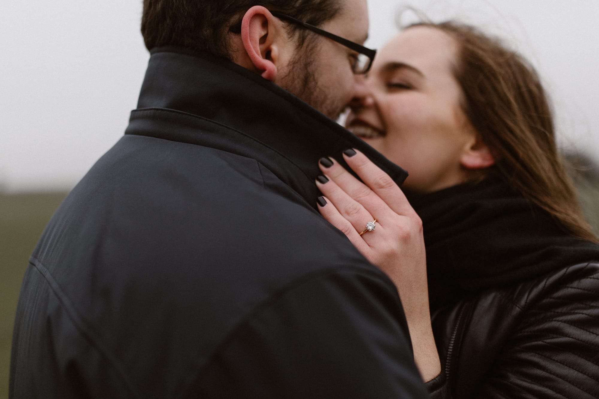 girl kissing boy on cold day at engagement shoot with gloucestershire wedding photographer