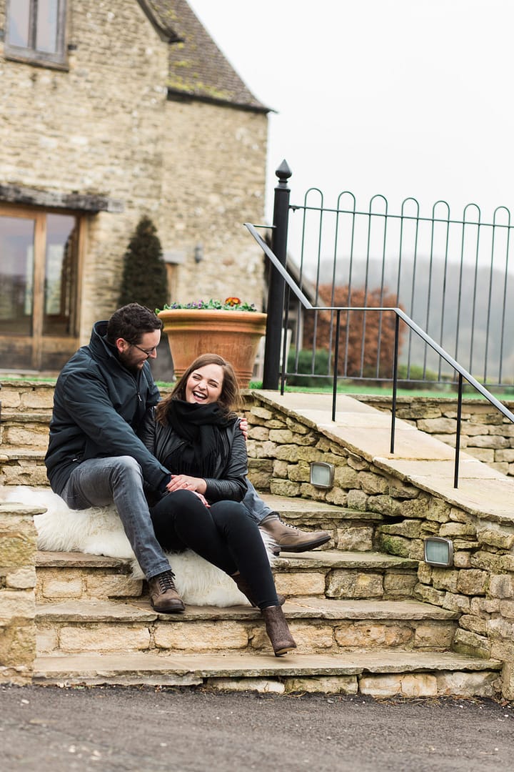 couple laughing on stairs for wedding photography at Kingscote Barn 